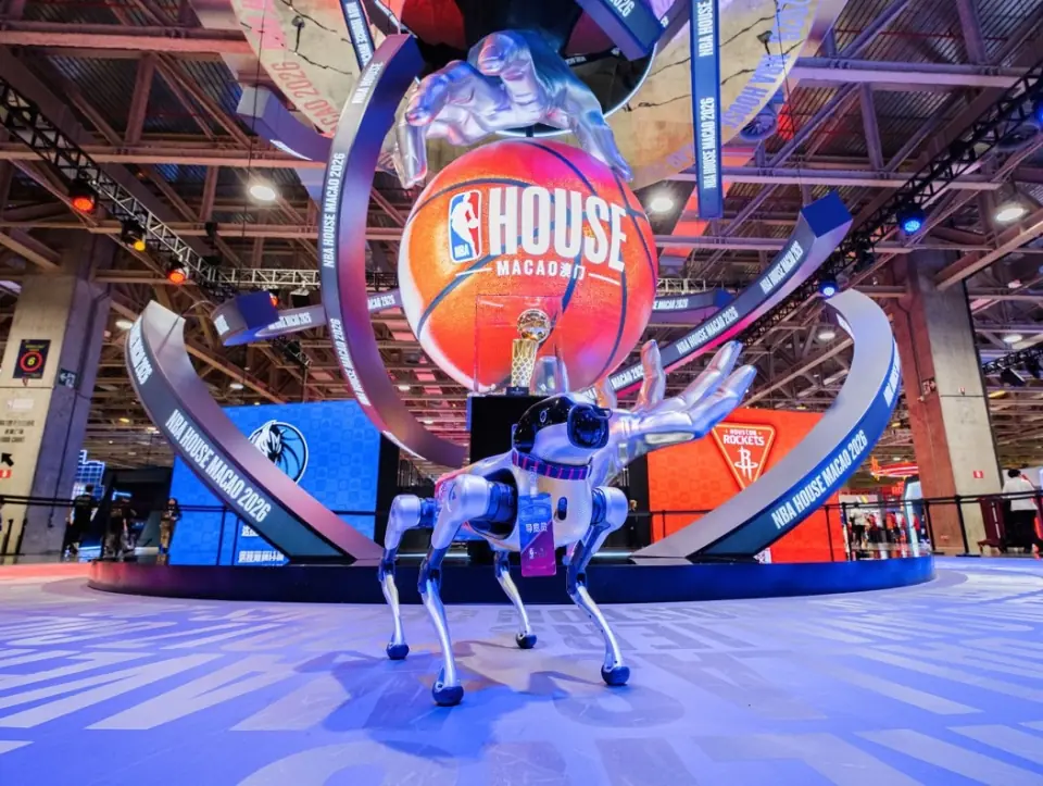 机器狗途途站在 NBA House 澳门 2026 场馆中央的巨型篮球装置前
